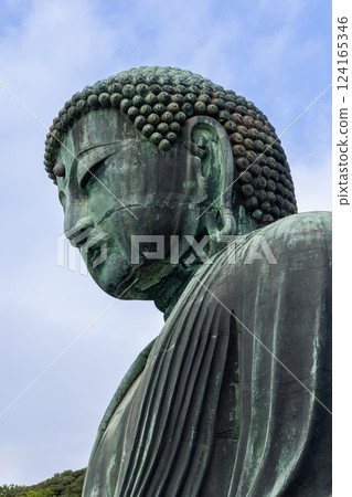 Kamakura Buddha capturing the serene expression sculpted hair and weathered bronze surface Kamakura Buddha capturing the serene expression sculpted hair and weathered bronze surface 124165346