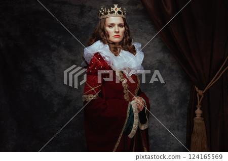 medieval queen in red dress with white collar and crown 124165569