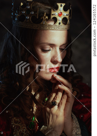 medieval queen in red dress with crown praying medieval queen in red dress with crown praying 124165572