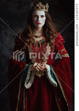 medieval queen in red dress with white makeup and crown 124165573