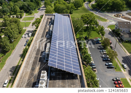 Apartment building with solar roof. Blue photovoltaic panels for producing clean ecological electric energy. Investing in renewable electricity concept 124165683