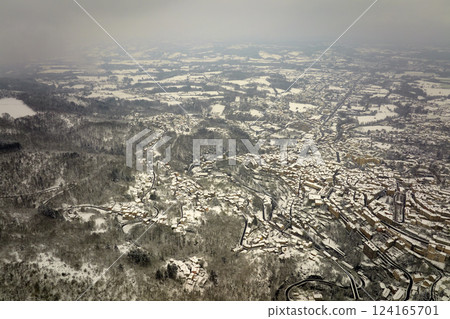 Aerial winter landscape of dense historic center of Thiers town in Puy-de-Dome department, Auvergne-Rhone-Alpes region in France. Rooftops of old buildings and narrow streets at snowfall 124165701