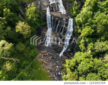 Aerial view of Whitewater Falls in Nantahala National Forest, North Carolina, USA. Clear water falling down from rocky boulders between green lush woods 124165704
