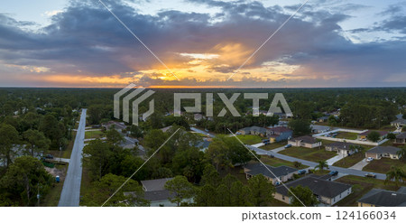 Aerial view of suburban landscape with private homes between green palm trees in Florida quiet residential area in evening Aerial view of suburban landscape with private homes between green palm trees in Florida quiet residential area in evening 124166034