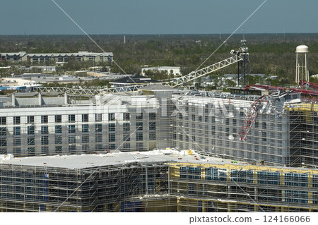 Aerial view of ruined by hurricane Ian construction crane on high apartment building site in Port Charlotte, USA 124166066