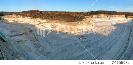 Aerial view of open pit mining site of limestone materials for construction industry with excavators and dump trucks 124166072