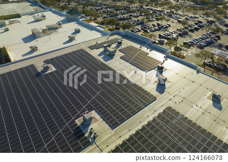 Aerial view of many photovoltaic panels installed on shopping mall roof top for producing of green ecological electricity. Production of sustainable energy concept 124166078