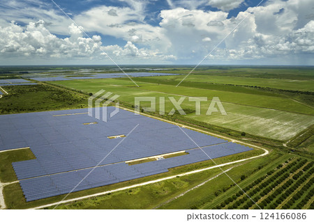 Aerial view of large sustainable electrical power plant with rows of solar photovoltaic panels for producing clean electric energy. Concept of renewable electricity with zero emission Aerial view of large sustainable electrical power plant with rows of solar photovoltaic panels for producing clean electric energy. Concept of renewable electricity with zero emission 124166086