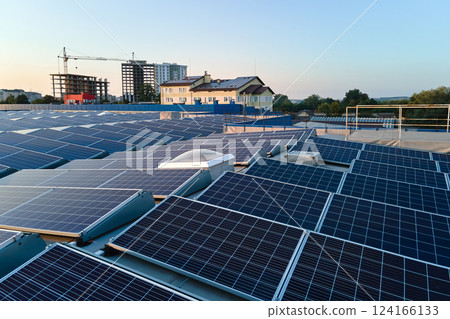Aerial view of blue photovoltaic solar panels mounted on industrial building roof for producing green ecological electricity. Production of sustainable energy concept 124166133