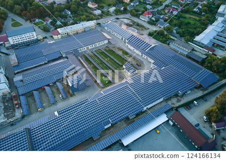 Aerial view of blue photovoltaic solar panels mounted on industrial building roof for producing green ecological electricity. Production of sustainable energy concept 124166134