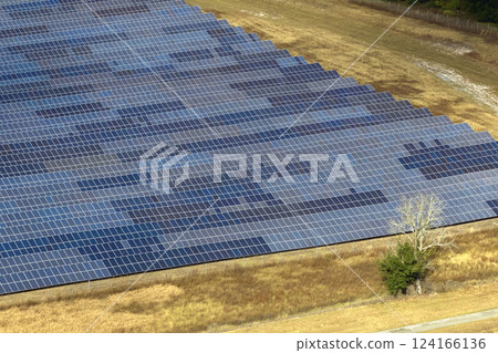 Aerial view of big sustainable electric power plant with many rows of solar photovoltaic panels for producing clean electrical energy. Renewable electricity with zero emission concept Aerial view of big sustainable electric power plant with many rows of solar photovoltaic panels for producing clean electrical energy. Renewable electricity with zero emission concept 124166136