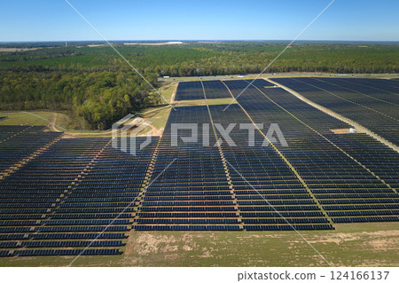 Aerial view of big sustainable electric power plant with many rows of solar photovoltaic panels for producing clean electrical energy. Renewable electricity with zero emission concept Aerial view of big sustainable electric power plant with many rows of solar photovoltaic panels for producing clean electrical energy. Renewable electricity with zero emission concept 124166137