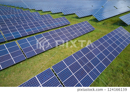 Aerial view of big sustainable electric power plant with many rows of solar photovoltaic panels for producing clean electrical energy. Renewable electricity with zero emission concept Aerial view of big sustainable electric power plant with many rows of solar photovoltaic panels for producing clean electrical energy. Renewable electricity with zero emission concept 124166139