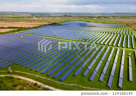 Aerial view of big sustainable electric power plant with many rows of solar photovoltaic panels for producing clean ecological electrical energy. Renewable electricity with zero emission concept. Aerial view of big sustainable electric power plant with many rows of solar photovoltaic panels for producing clean ecological electrical energy. Renewable electricity with zero emission concept. 124166145