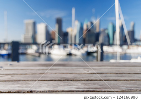 An empty wooden barbecue table set outdoors with a blurred view of the iconic Manhattan skyline An empty wooden barbecue table set outdoors with a blurred view of the iconic Manhattan skyline 124166990