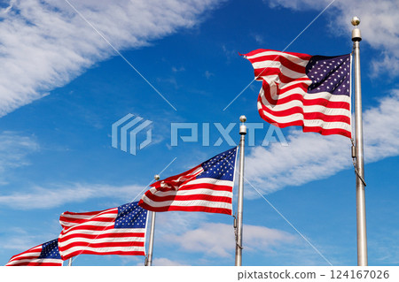 Rows of American flags waving against a sunny sky 124167026