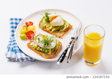 Delicious avocado toasts topped with perfectly cooked poached eggs 124167150