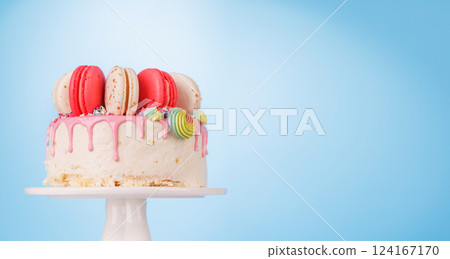 A beautifully decorated cake adorned with colorful macarons 124167170