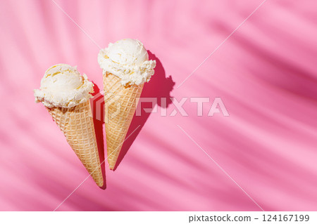 A refreshing ice cream cones set against a vibrant pink background 124167199