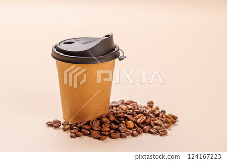 A paper cup of freshly brewed coffee surrounded by rich, aromatic roasted coffee beans A paper cup of freshly brewed coffee surrounded by rich, aromatic roasted coffee beans 124167223