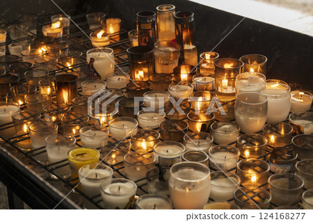 A collection of lit prayer candles 124168277