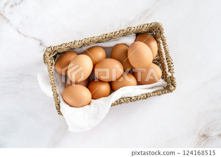 Basket of brown eggs on table, essential ingredient in cuisine and staple food 124168515
