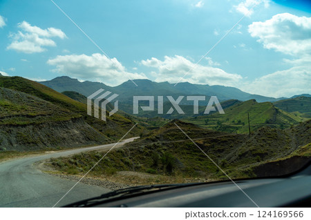 A view of a mountain range with a road in the middle A view of a mountain range with a road in the middle 124169566