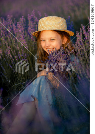 Lavender Girl Hat: Girl smiling, sitting in lavender field, sunset, holding flowers, enjoying summer day. 124169667