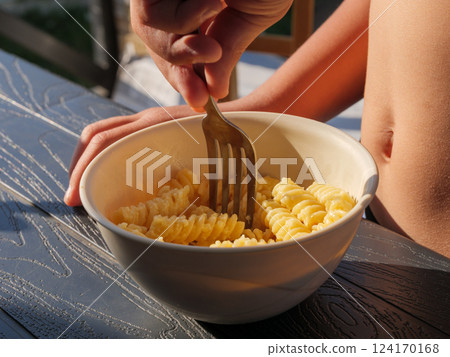 Dining outdoors while enjoying pasta on a sunny afternoon in a cozy setting Dining outdoors while enjoying pasta on a sunny afternoon in a cozy setting 124170168