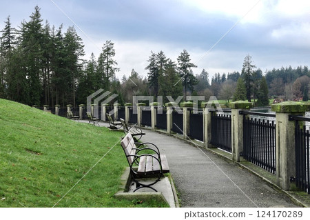 bench on green grass in the park next to the railing 124170289
