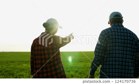 Man and woman farmers colleagues shaking hands at sunset green wheat field closeup. Agricultural workers partners friendly handshaking work as team harvest growth cultivation outdoor sunlight Man and woman farmers colleagues shaking hands at sunset green wheat field closeup. Agricultural workers partners friendly handshaking work as team harvest growth cultivation outdoor sunlight 124170736