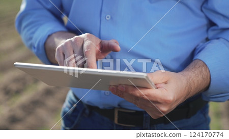 Businessman digital agricultural farmer with tablet. Hands male professional using tablet. Creation planting plans harvest schedules labor allocation aspects of agricultural business farm management. 124170774
