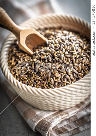 Milk thistle seeds in bowl on kitchen table. 124170816