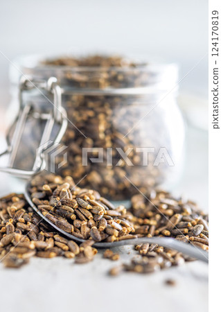 Milk thistle seeds in spoon on kitchen table. Milk thistle seeds in spoon on kitchen table. 124170819