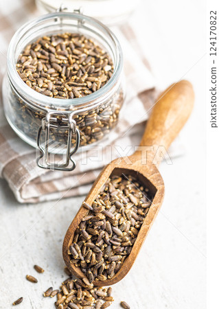 Milk thistle seeds in scoop on kitchen table. 124170822