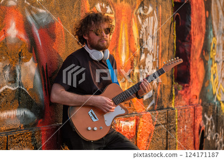 Street musician playing electric guitar in the street 124171187