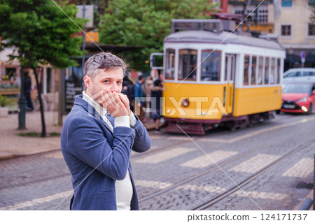 Man plays harmonica outdoors in city street 124171737