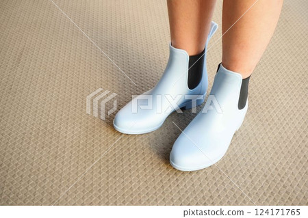 Short rain boots for kids. A fifth-grade girl is wearing light blue rain boots. Short rain boots for kids. A fifth-grade girl is wearing light blue rain boots. 124171765
