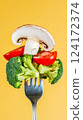 Forkful of Fresh Vegetables Broccoli, Mushroom, and Tomato on Yellow Background Forkful of Fresh Vegetables Broccoli, Mushroom, and Tomato on Yellow Background 124172374