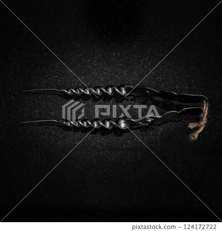 A Twisted Black Sculpture Set Against a Dark Background that Captivates the Viewer 124172722