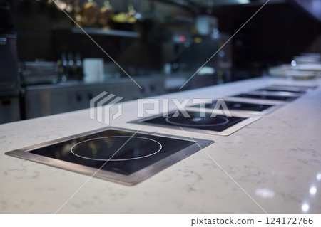 A Contemporary Modern Kitchen Featuring Induction Cooktops on Elegant Marble Countertops 124172766