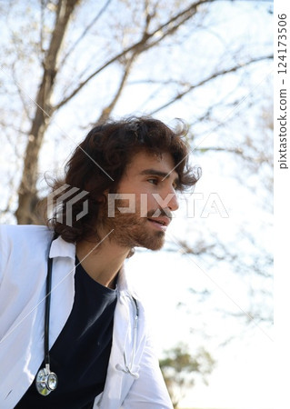 Young Charming Man Doctor Trainee Repeats Study Outside in University Field Young Charming Man Doctor Trainee Repeats Study Outside in University Field 124173506