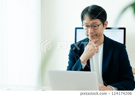 Businessman operating a personal computer 124174206