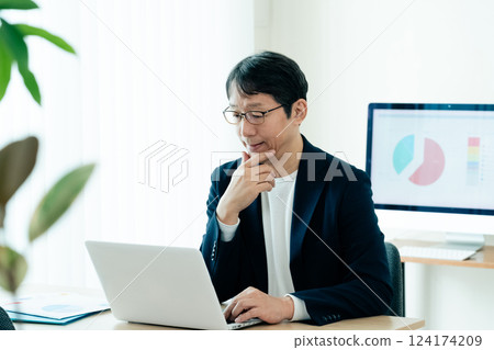 Businessman operating a personal computer 124174209