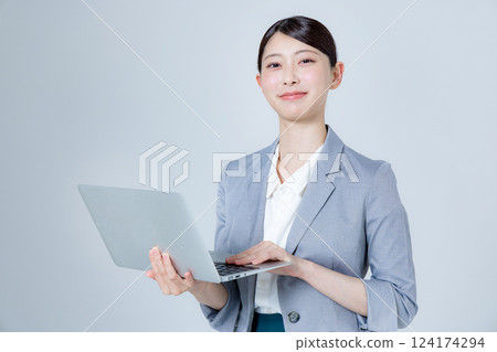A female business person giving directions with a laptop A female business person giving directions with a laptop 124174294