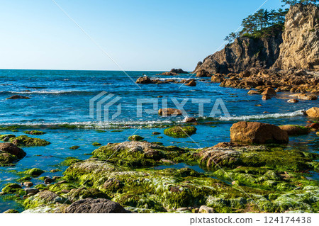 Rocky coast and blue sea on a sunny day Rocky coast and blue sea on a sunny day 124174438