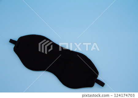 Eye mask on light blue background Eye mask on light blue background 124174703