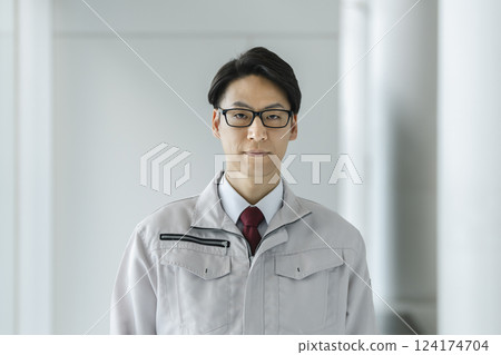 一名 40 多歲、身穿工作服的男子看著鏡頭 一名 40 多歲、身穿工作服的男子看著鏡頭 124174704