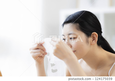 一名手持面膜的女子 124175039