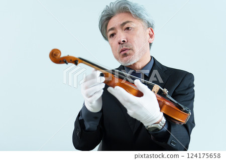Man inspecting a violin 124175658